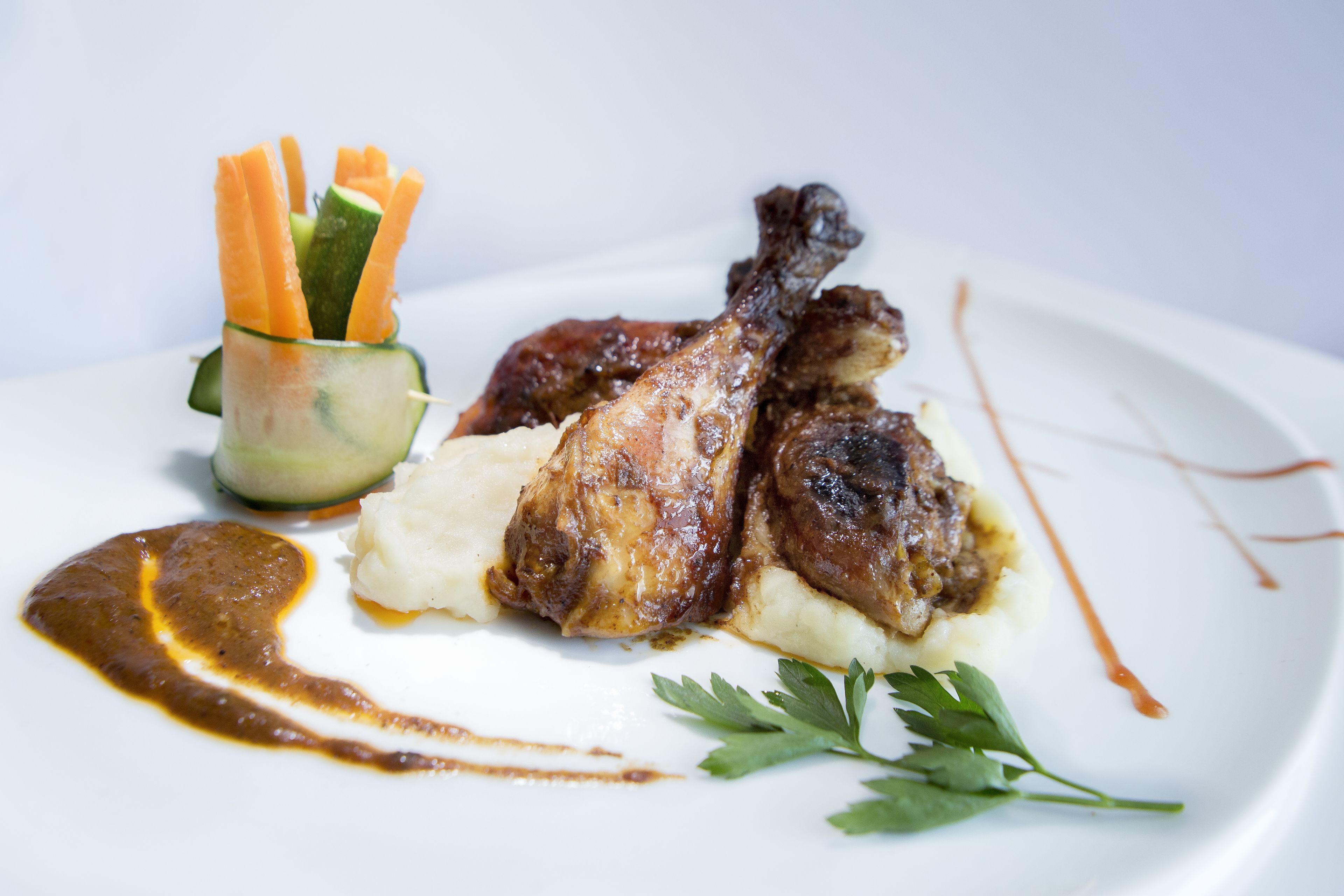 Une assiette contenant du poulet rôti, de la purée de pommes de terre et des carottes en accompagnement.