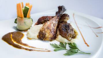 Une assiette contenant du poulet rôti, de la purée de pommes de terre et des carottes en accompagnement.