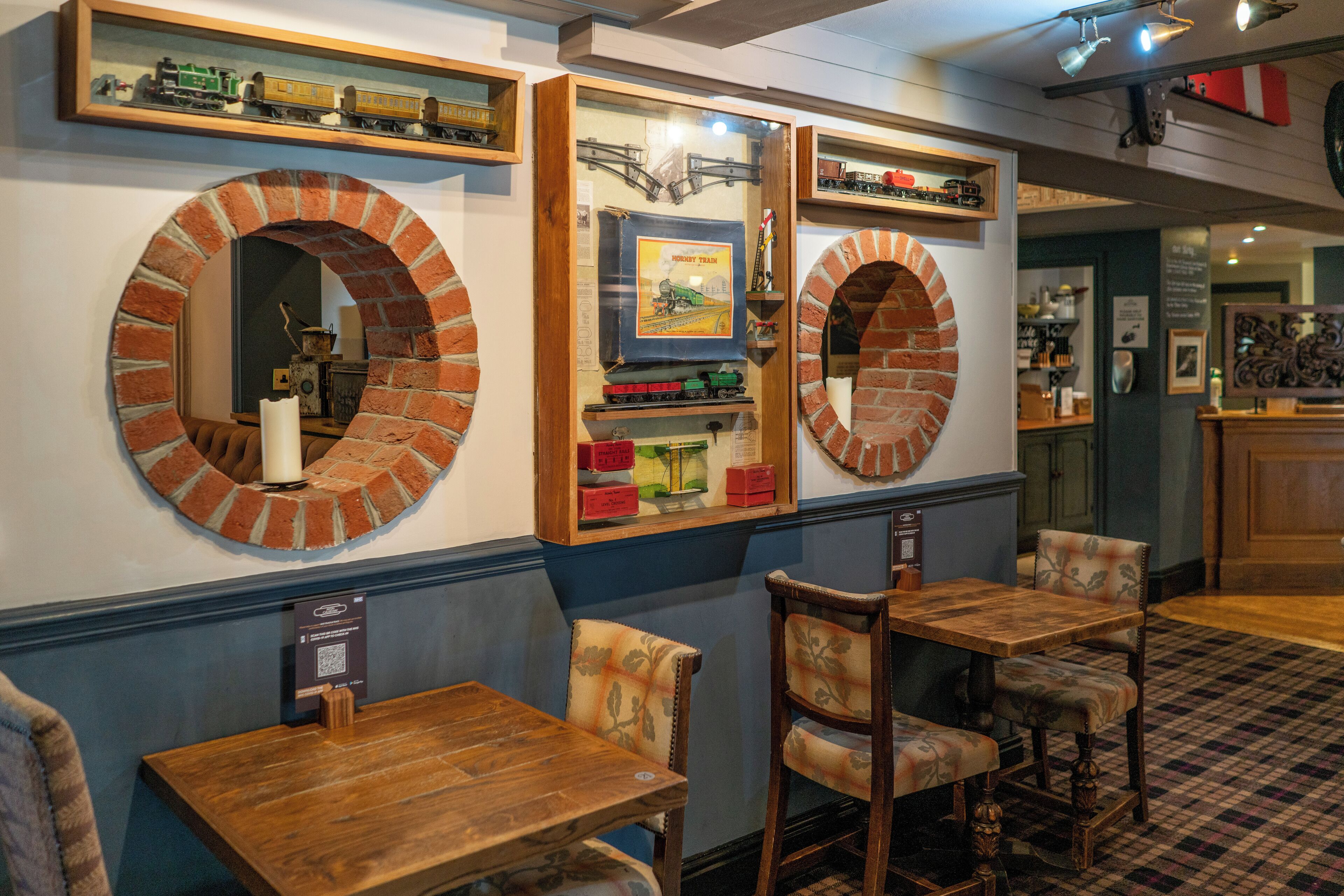 L’intérieur d’un restaurant avec des miroirs encadrés d’arcs en briques, des tables et des chaises en bois.
