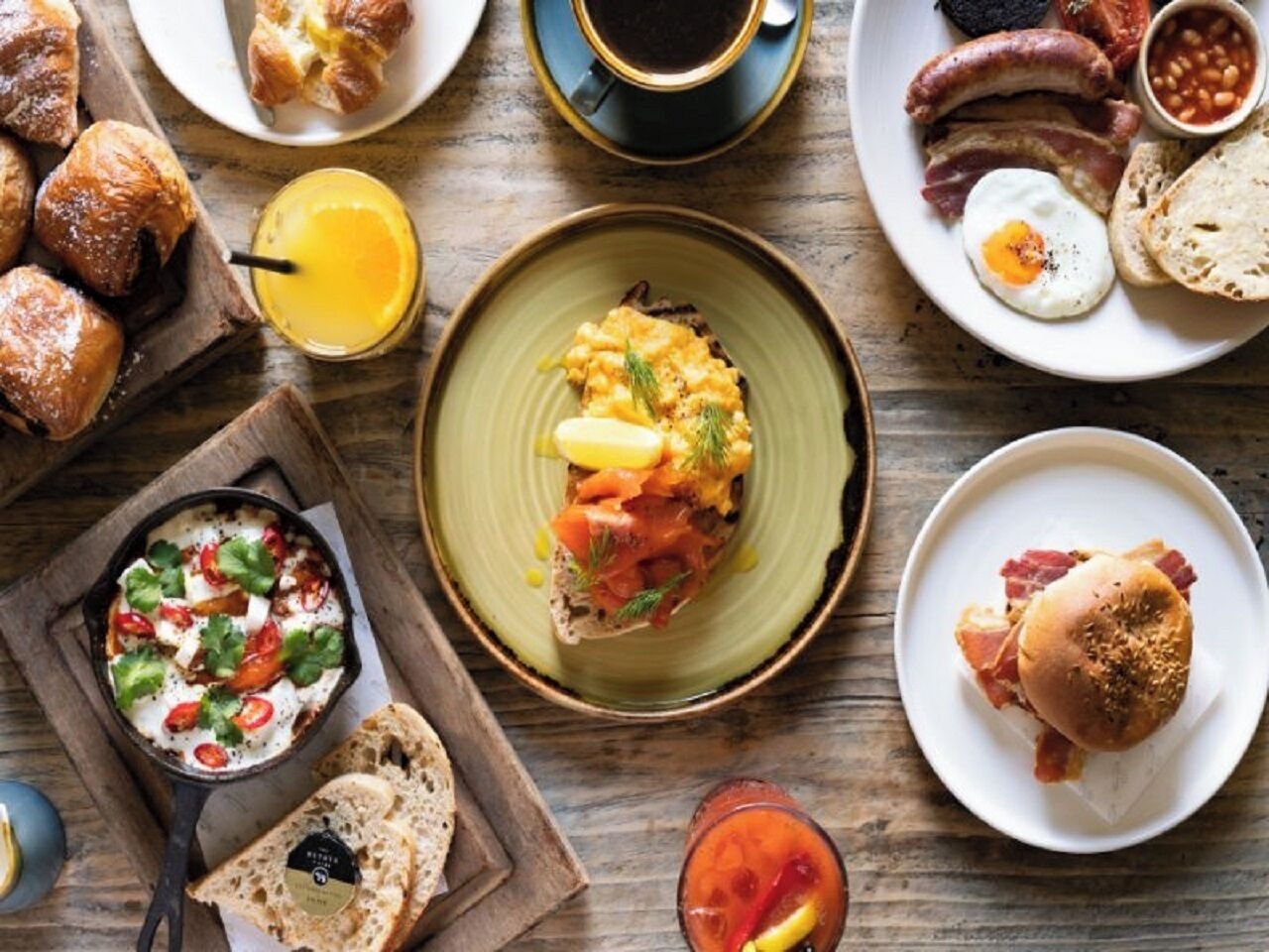 A breakfast spread with various dishes including eggs, sausages, and toast.