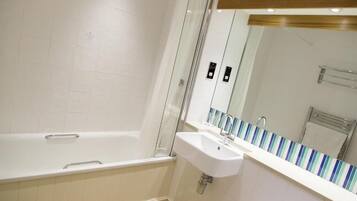 A modern bathroom with a bathtub, a sink, and a mirror.