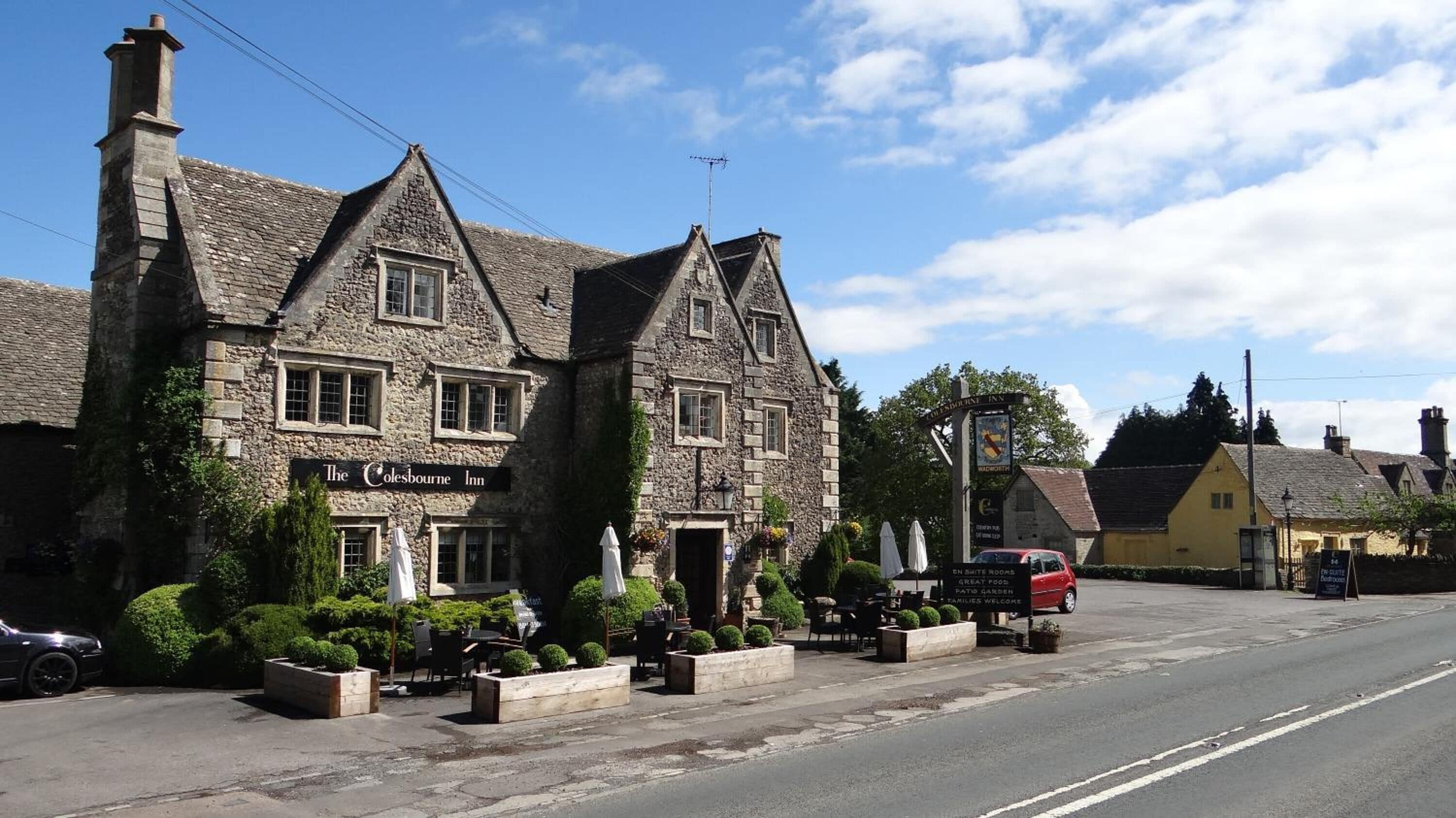 The Colesbourne Inn, a stone building with multiple windows and a traditional design.