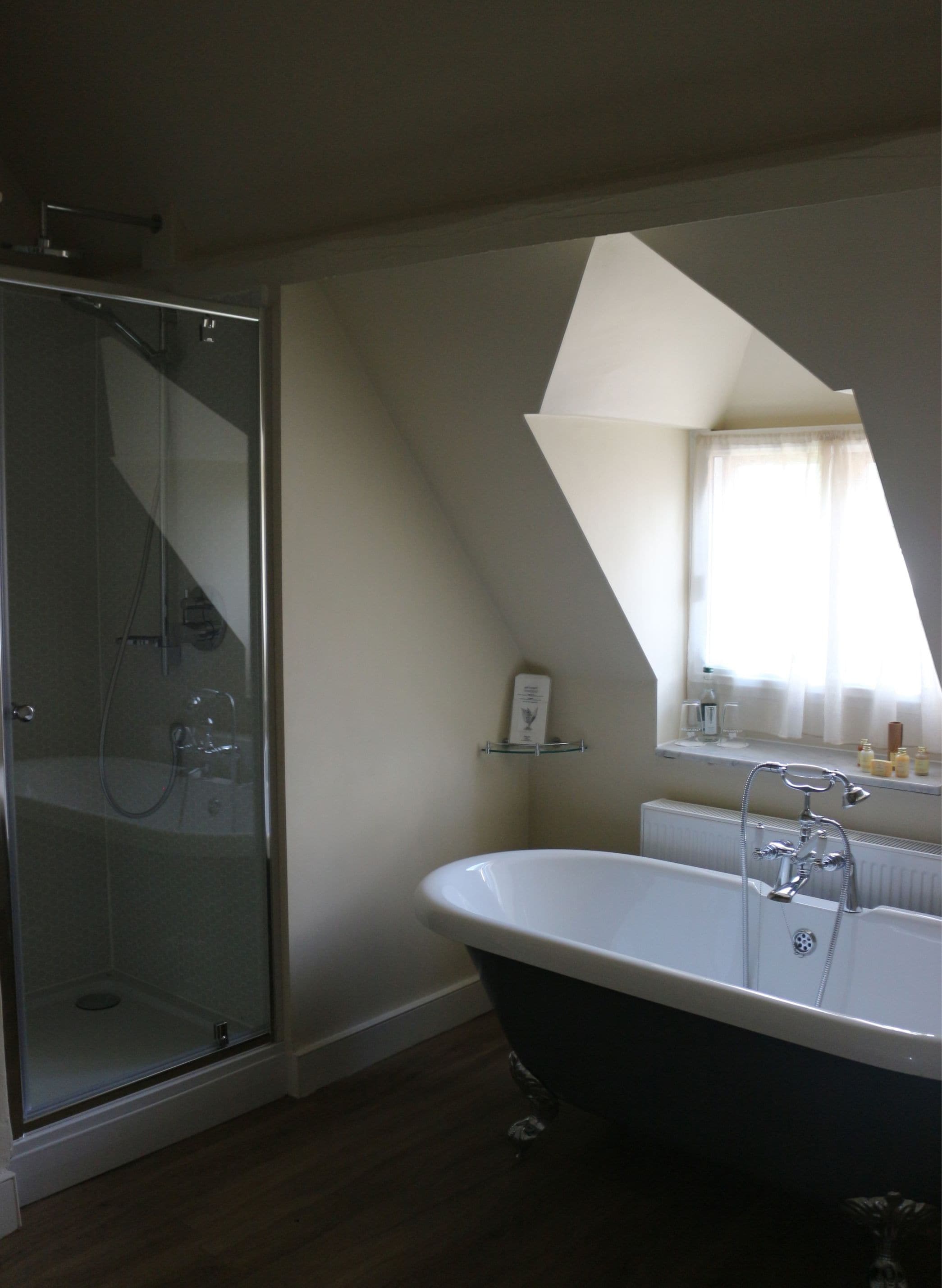 A bathroom with a glass-enclosed shower, a freestanding bathtub, and a mirror above the sink.
