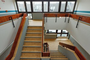 A staircase with wooden steps and metal railings, leading to an upper floor. - Trip Inn City Hotel Krefeld (Krefeld)