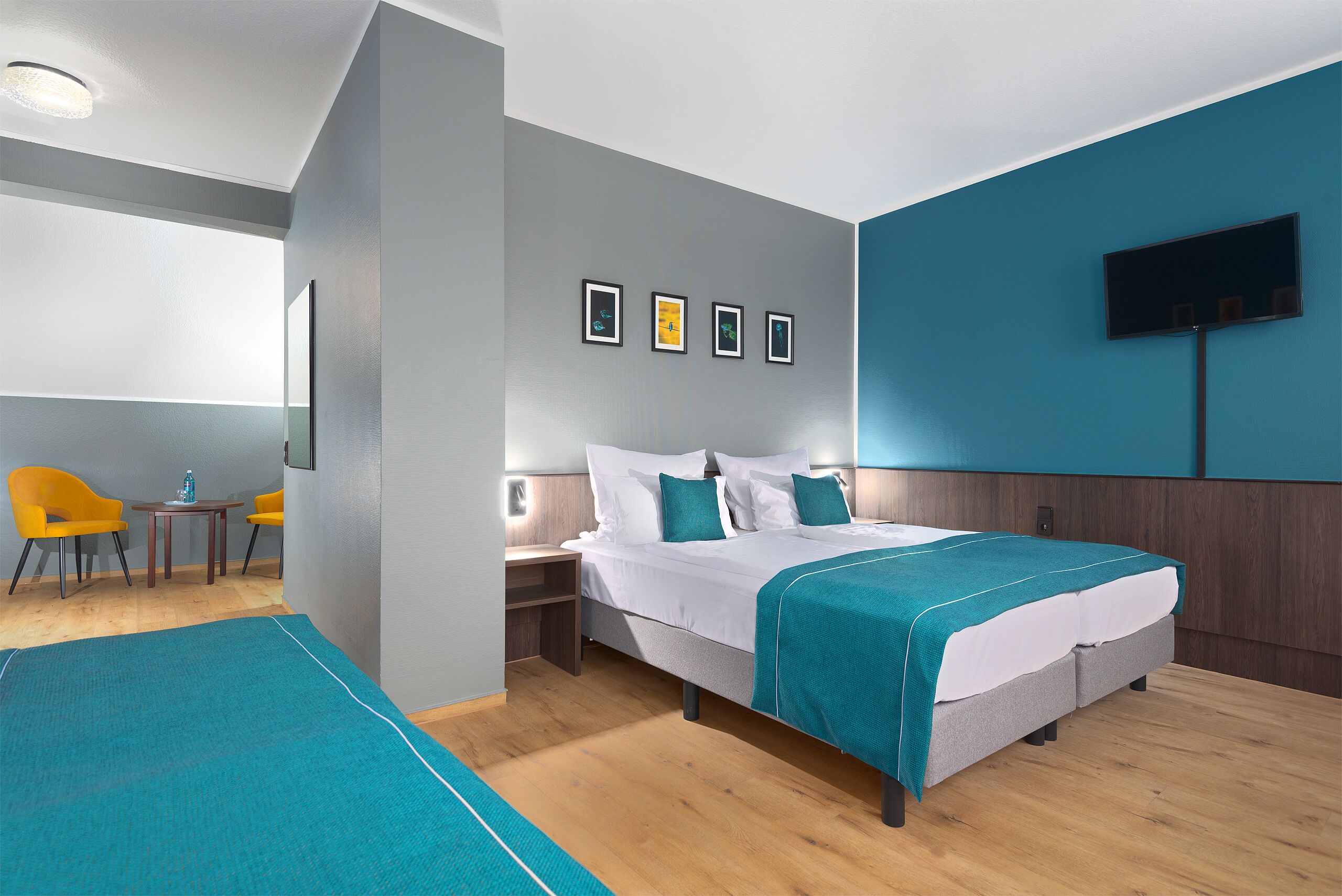 Una habitación de hotel moderna con una cama, un televisor, un escritorio y una silla.