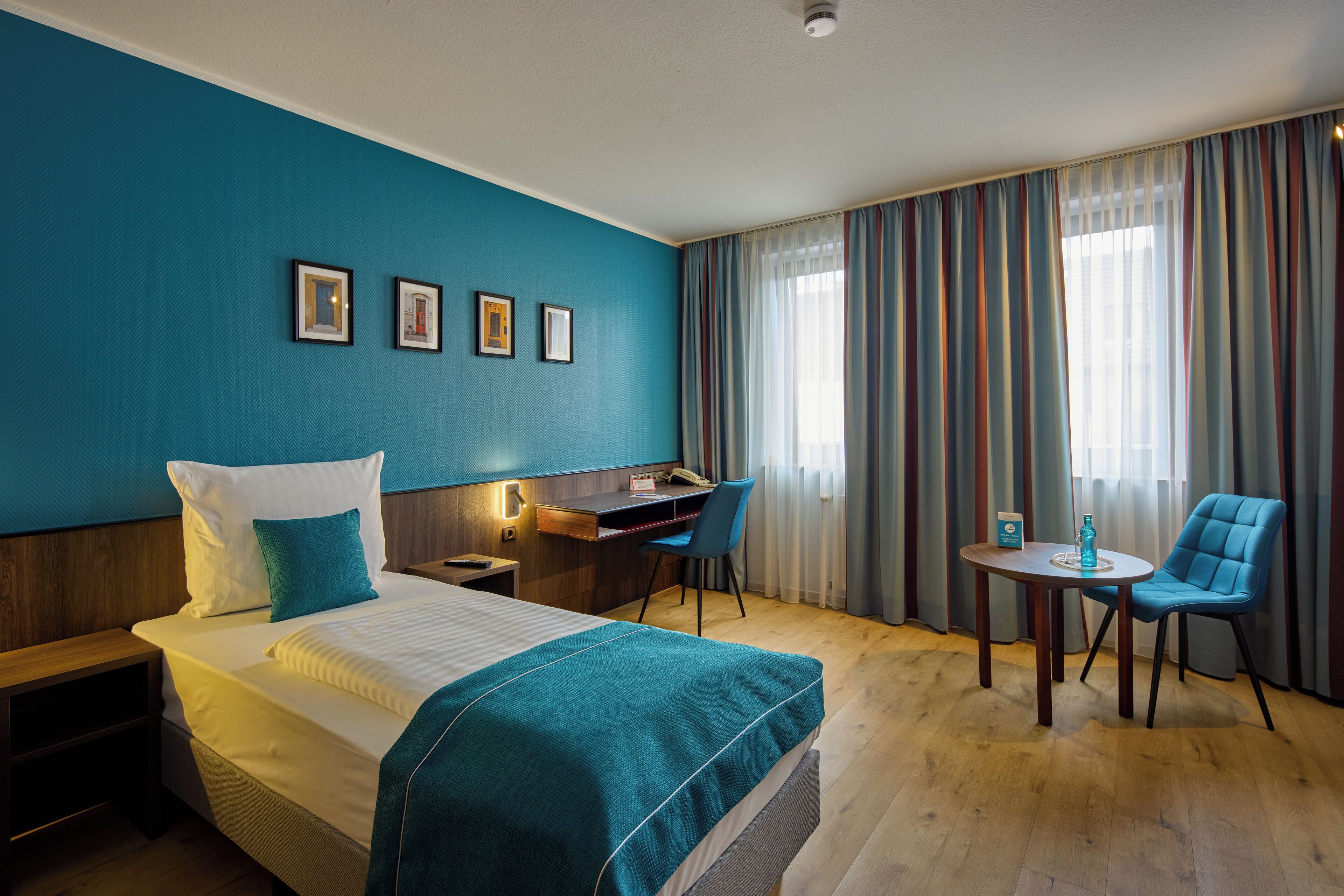 Ein Hotelzimmer mit Bett, Schreibtisch und zwei Stühlen.