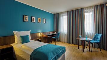 Ein Hotelzimmer mit Bett, Schreibtisch und zwei Stühlen.