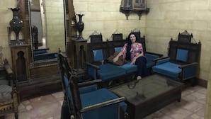 A room with a large ornate mirror, blue upholstered sofas, and a traditional coffee table. - Arabian Nights Hotel (Cairo)