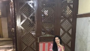 A room with a wooden partition, a red sofa, and a marble floor. - Arabian Nights Hotel (Cairo)