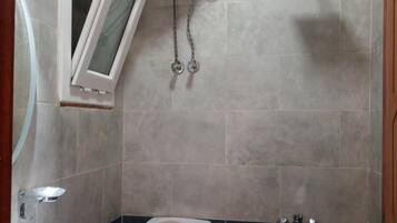 A bathroom with a toilet, sink, and a water heater mounted on the wall.