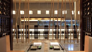 A restaurant with a traditional Asian design, featuring bamboo decorations, black chairs, and a sushi bar in the background. - Sheraton Wuxi Binhu Hotel (Wuxi)