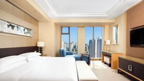 A modern hotel room with a large bed, a desk, a chair, and a TV. - Sheraton Wuxi Binhu Hotel (Wuxi)
