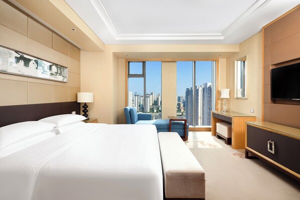 A modern hotel room with a large bed, a desk, a chair, and a TV. - Sheraton Wuxi Binhu Hotel (Wuxi)