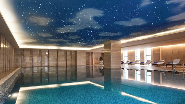 An indoor swimming pool with a starry sky ceiling, lounge chairs, and a modern design. - Sheraton Wuxi Binhu Hotel (Wuxi)