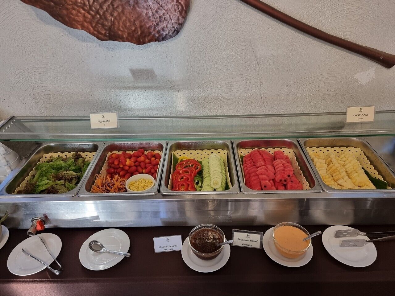Un buffet con diverse opzioni tra cui verdure, frutta e condimenti.