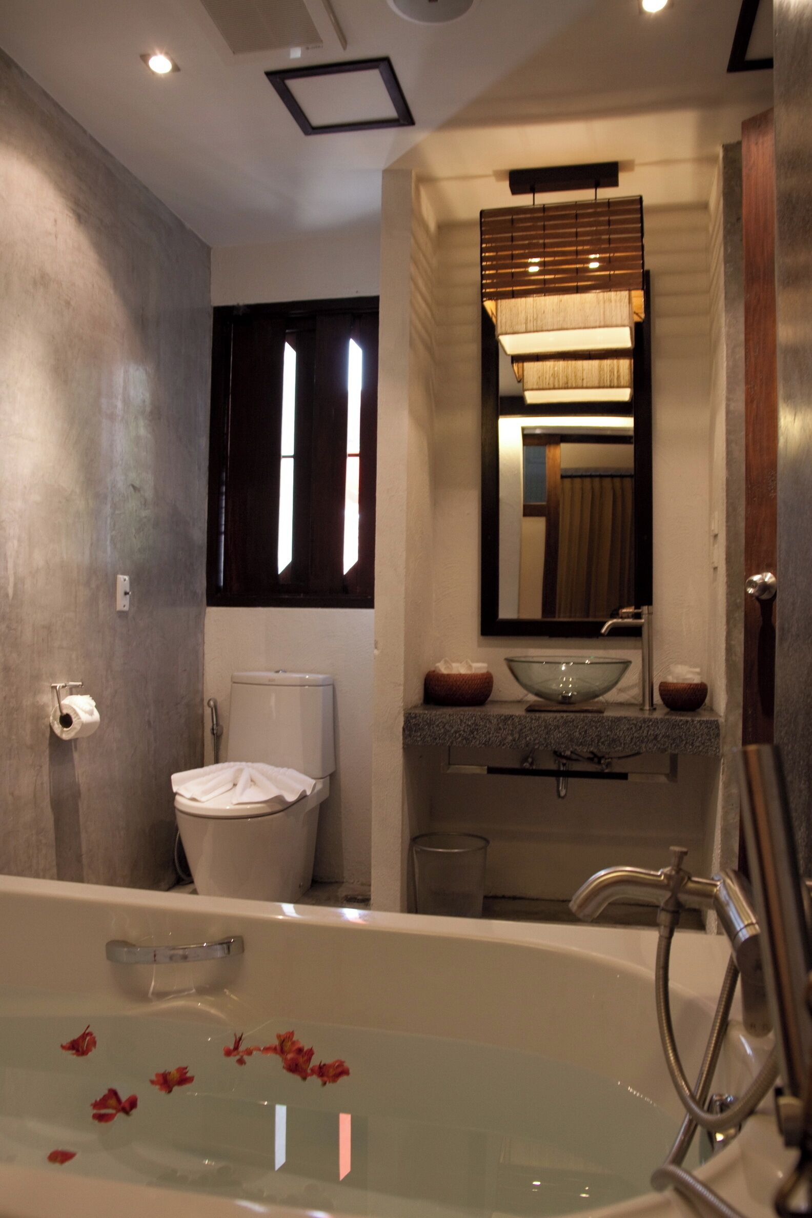 A bathroom with a bathtub, toilet, sink, and mirror.
