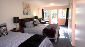 A hotel room with two beds, a large window, and a painting on the wall. - Anndion Lodge Motel and Function Centre (Whanganui)