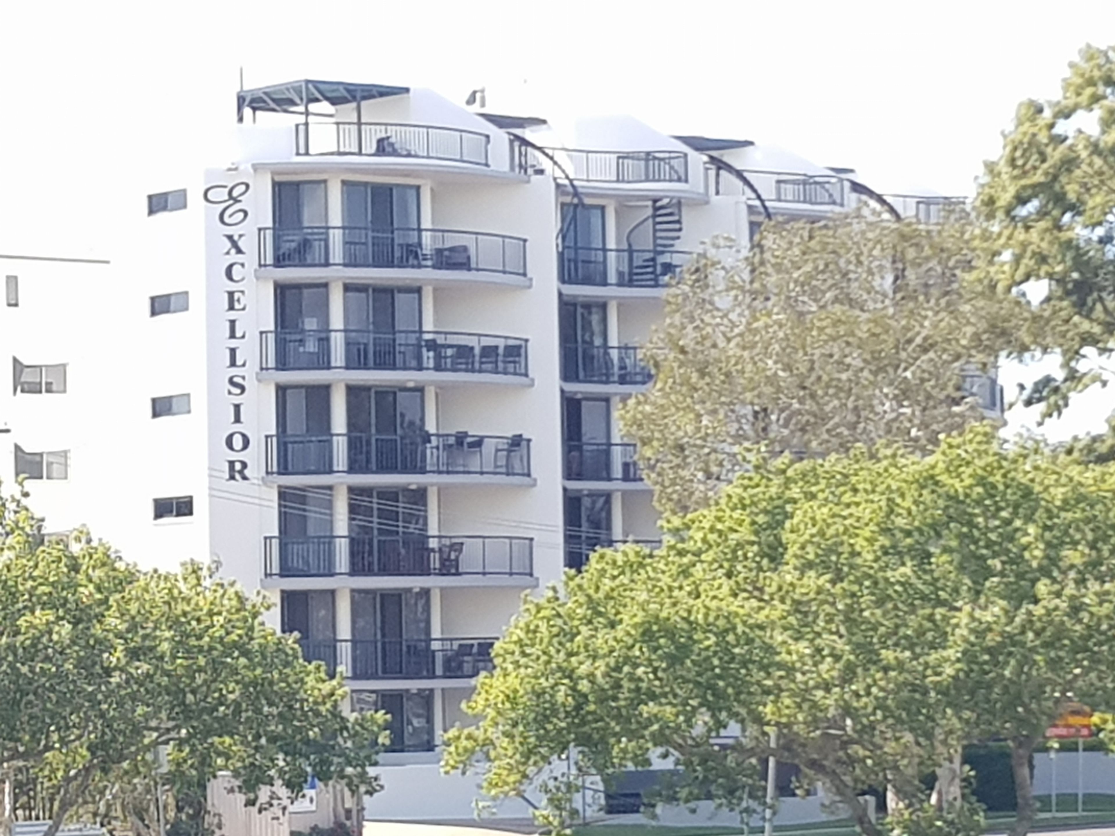 A multi-story hotel with balconies and a sign reading "Excellisior".