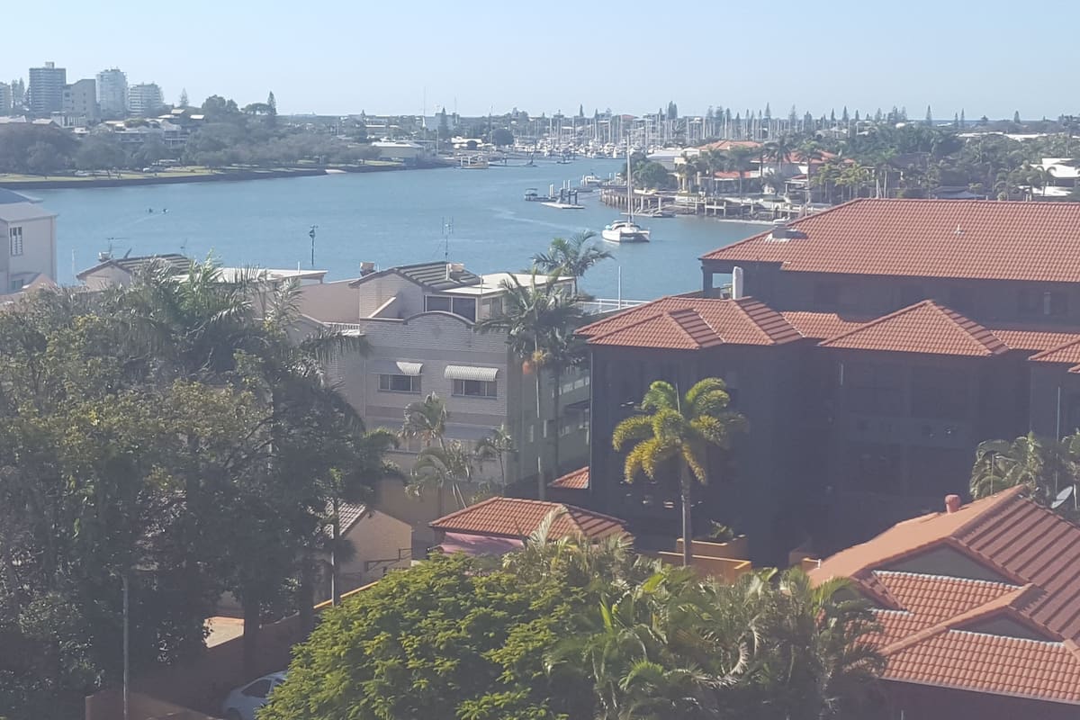 A coastal cityscape with residential buildings, a marina, and boats.