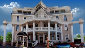 A large, multi-story building with a grand entrance, a fountain, and a pool. - Villa Venezia (Odesa)