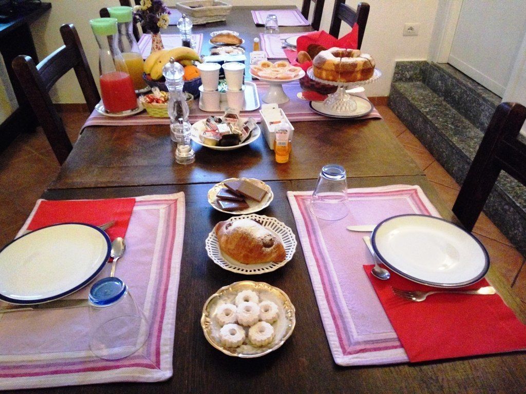 A dining table set with various breakfast items, including pastries, fruits, and beverages.