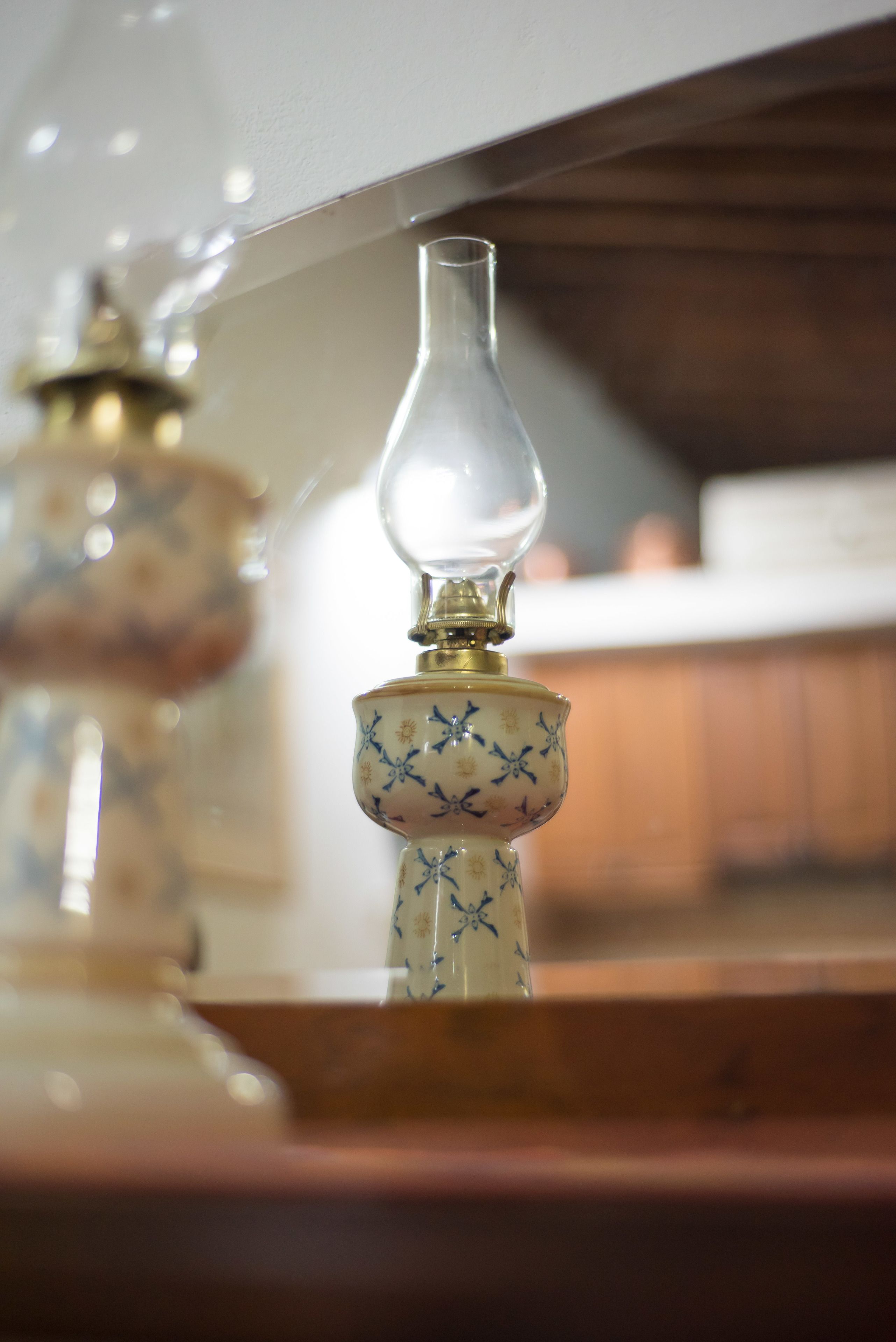 Un gros plan d’une lampe avec un abat-jour en verre et un pied orné de motifs.