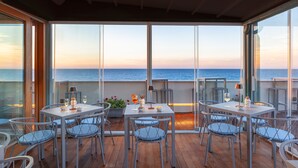 A dining area with a view of the sea, featuring a table set with glasses and a candle. - Residence La Gancia (Trapani)