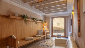A modern living room with a wooden bench, a sofa, and a patterned rug. - Residence La Gancia (Trapani)