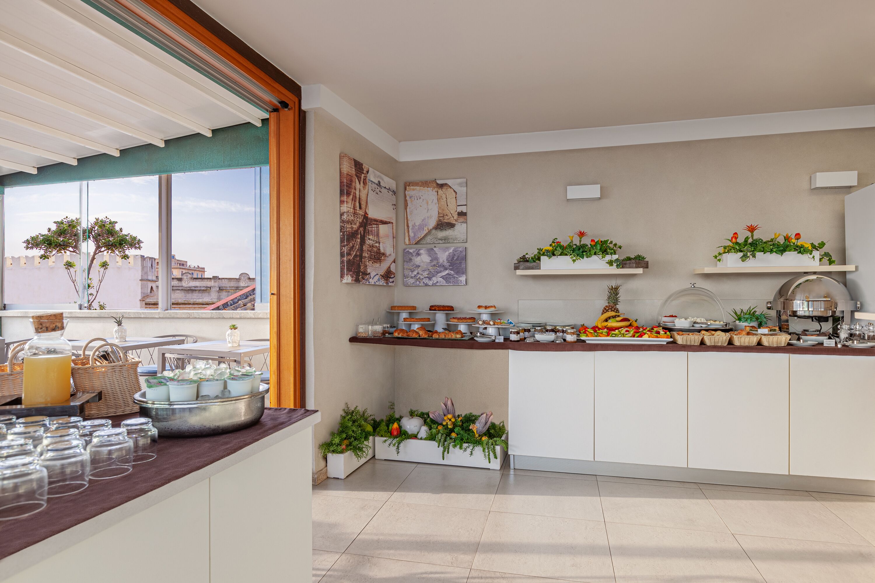 Een moderne keuken met een ontbijtbalk, diverse etenswaren en decoratieve planten.