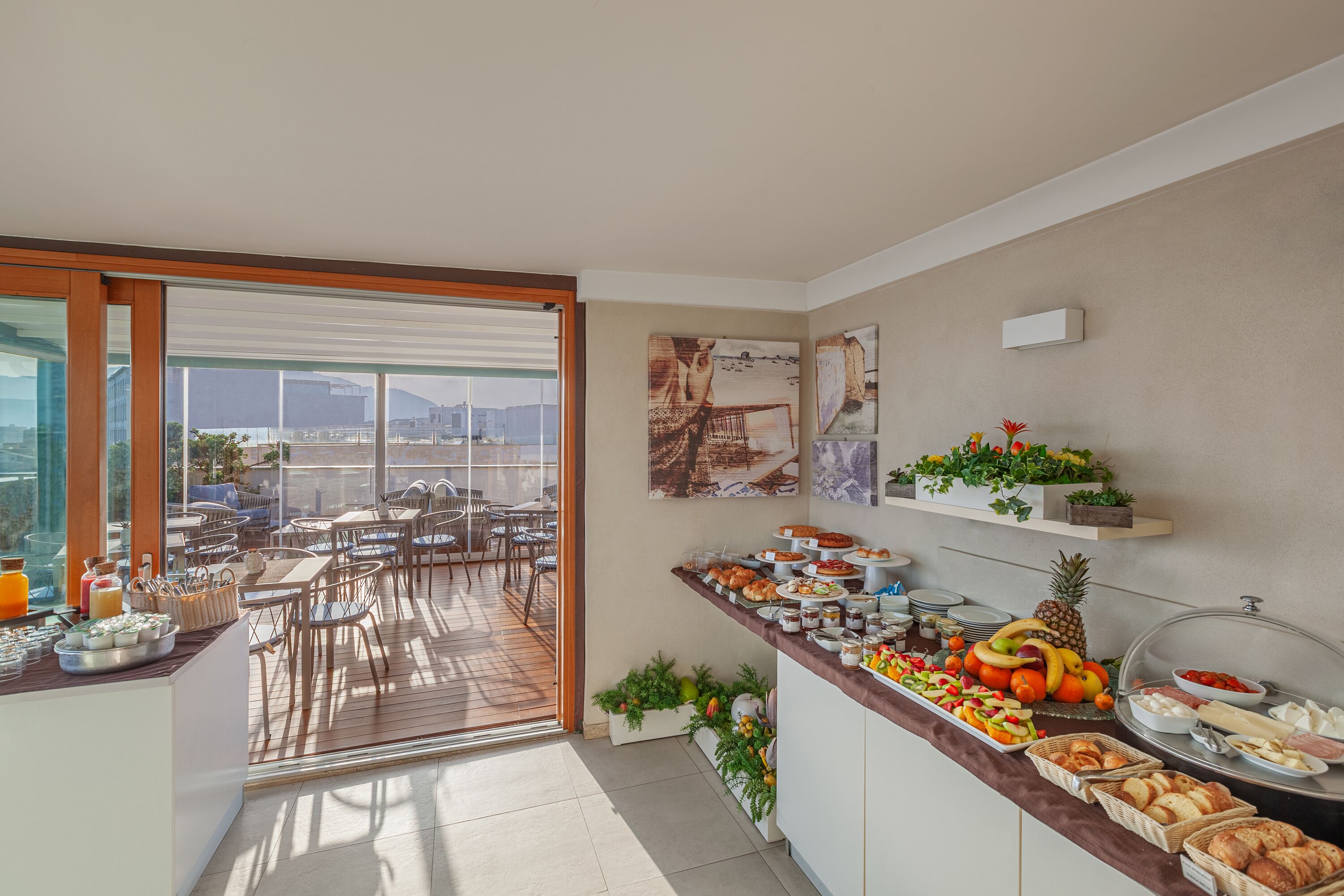Ein Frühstücksbuffet mit verschiedenen Speisen und einer Terrasse mit Sitzgelegenheiten im Freien.