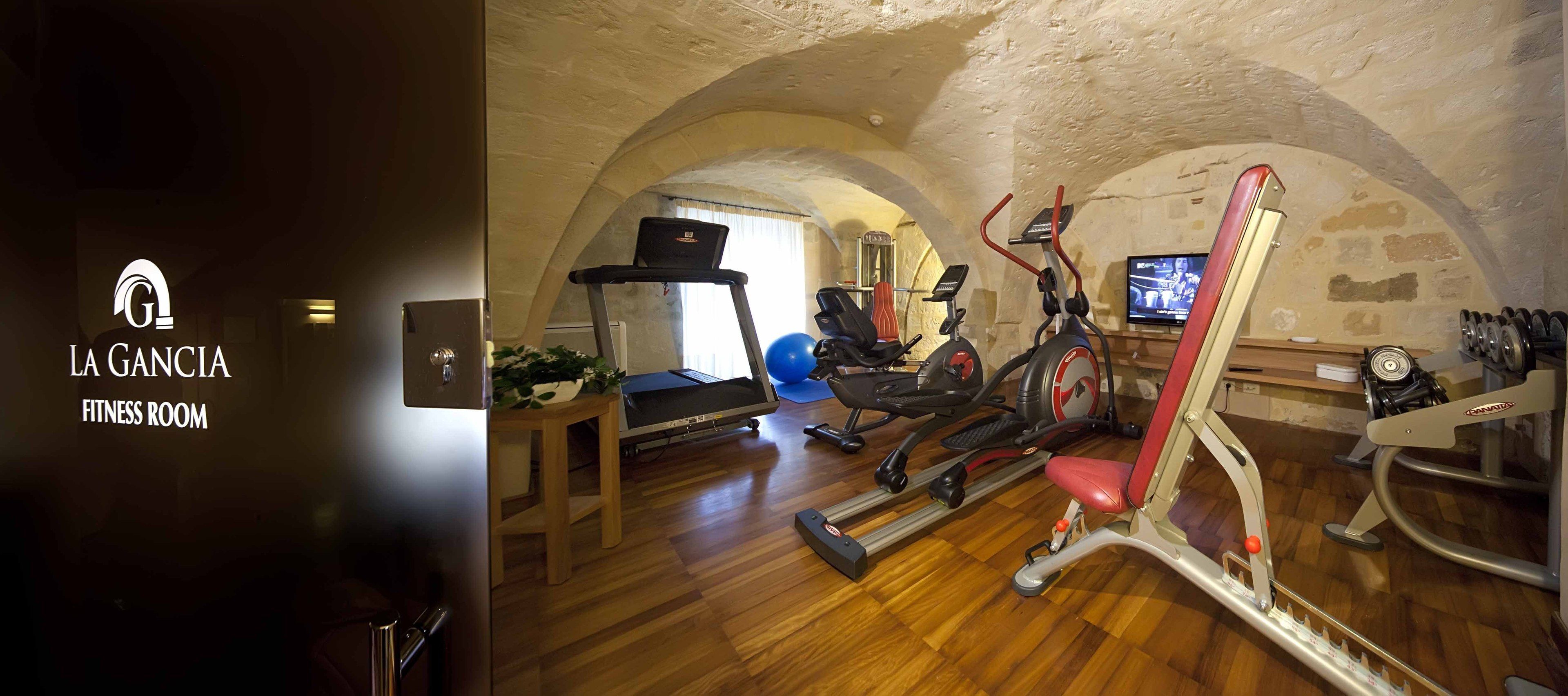 Un gimnasio con cinta de correr, elíptica y máquinas de pesas.