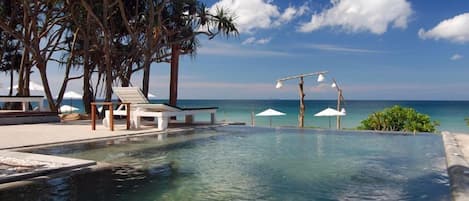 Una piscina al aire libre, sillones reclinables de piscina