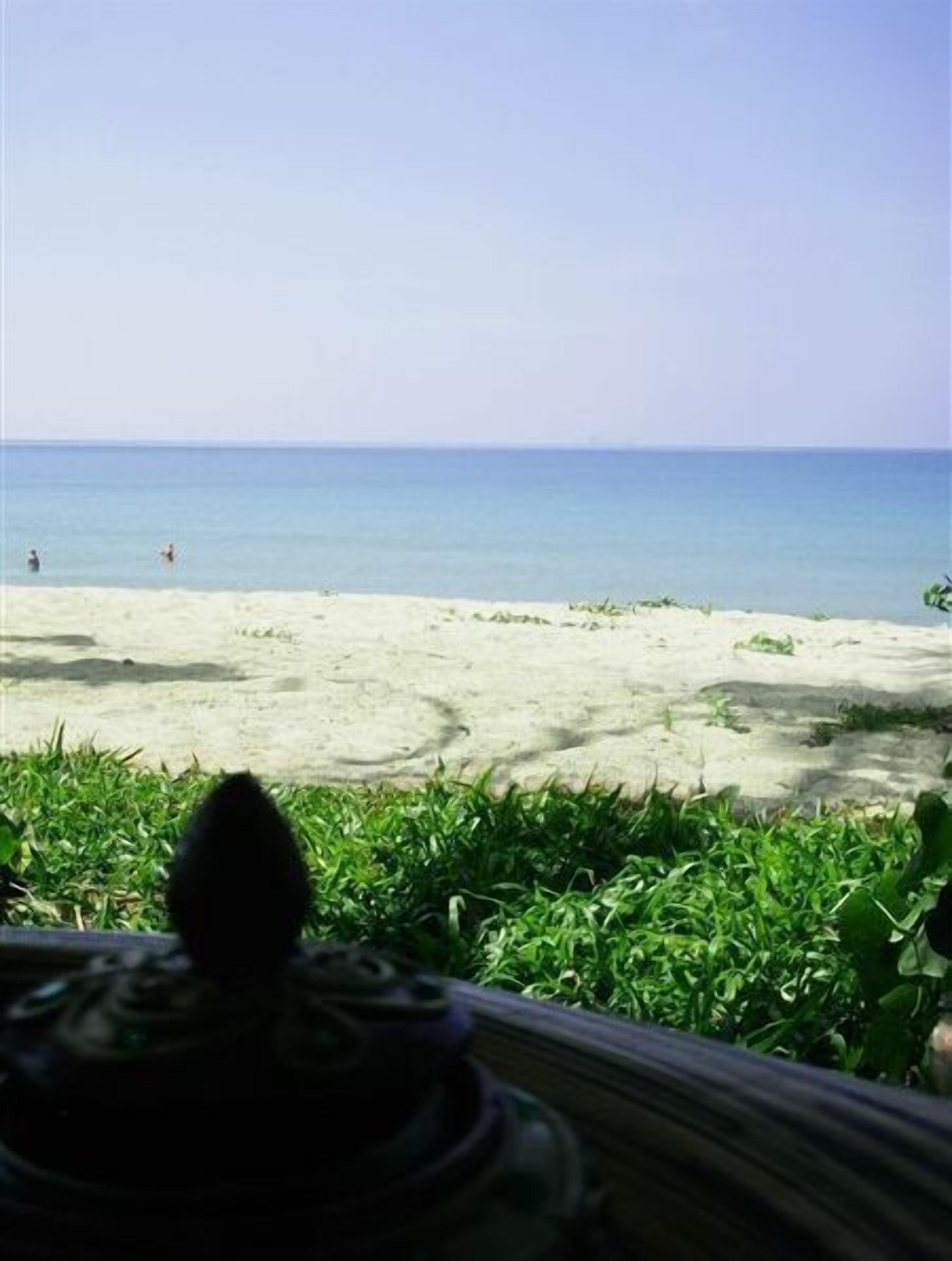 A beach view with a sandy shore and calm sea.
