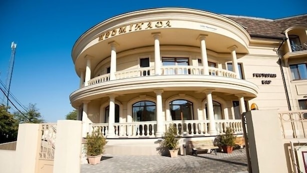 Un bâtiment doté d’une façade incurvée, de colonnes et d’un balcon.