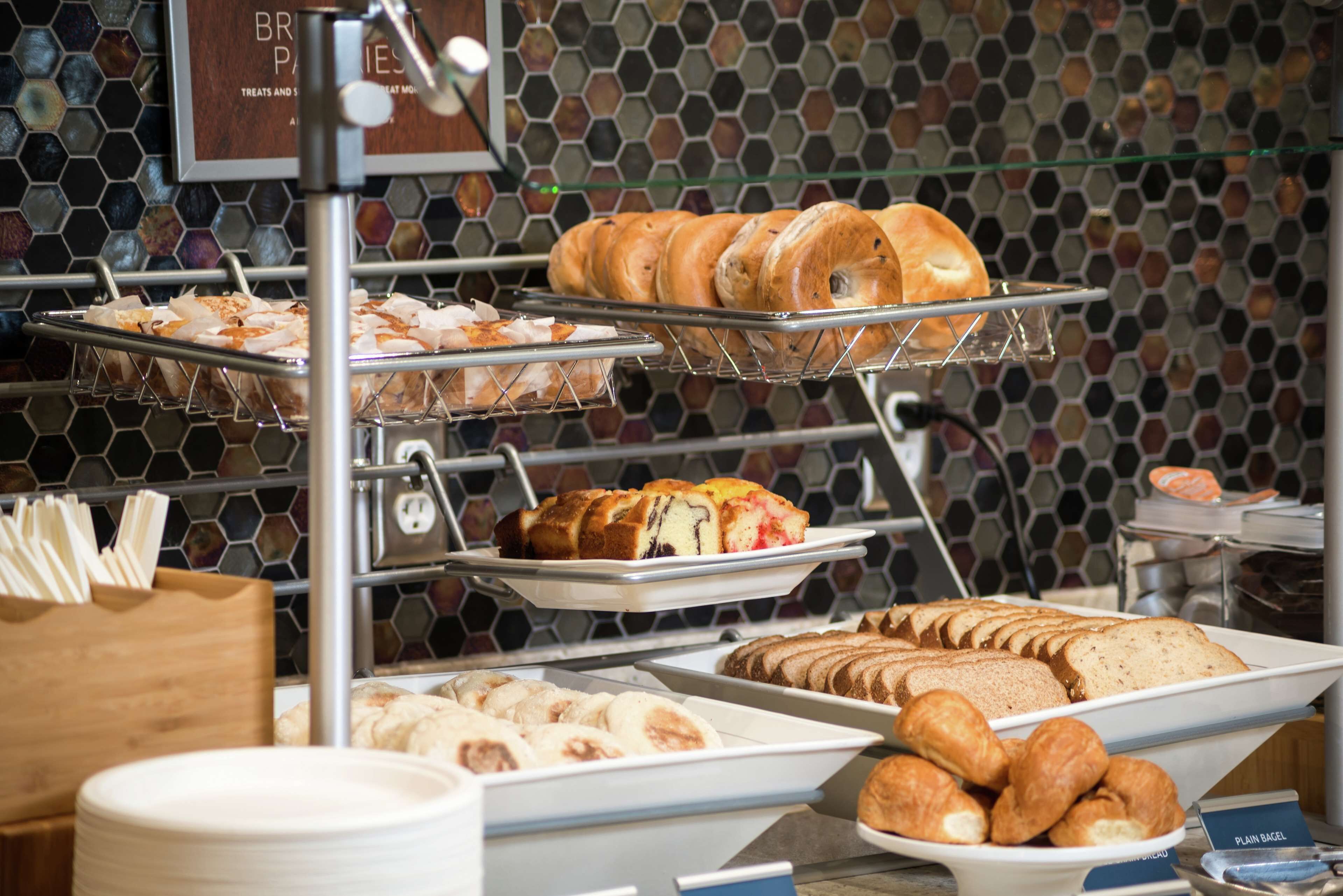 A bakery display with various baked goods like bagels, pastries, and bread.