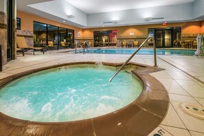 A hot tub with a pool adjacent to it, surrounded by lounge chairs and a seating area with tables. - Hampton Inn & Suites Tulsa/Catoosa (Catoosa)