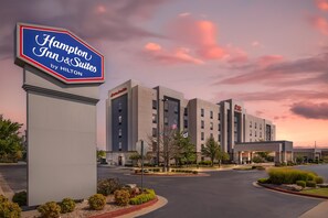 A hotel with a prominent sign for Hampton Inn & Suites by Hilton, featuring a modern building with multiple floors and a parking lot. - Hampton Inn & Suites Tulsa/Catoosa (Catoosa)