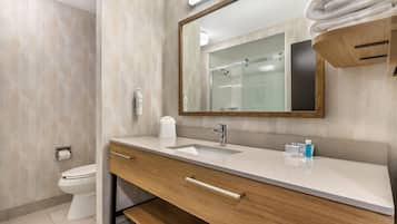 Un baño moderno con inodoro, lavamanos, tocador y espejo.