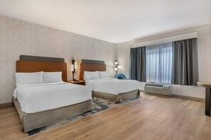 A hotel room with two beds, a desk, a chair, a window with curtains, and an air conditioning unit. - Hampton Inn & Suites Tulsa/Catoosa (Catoosa)