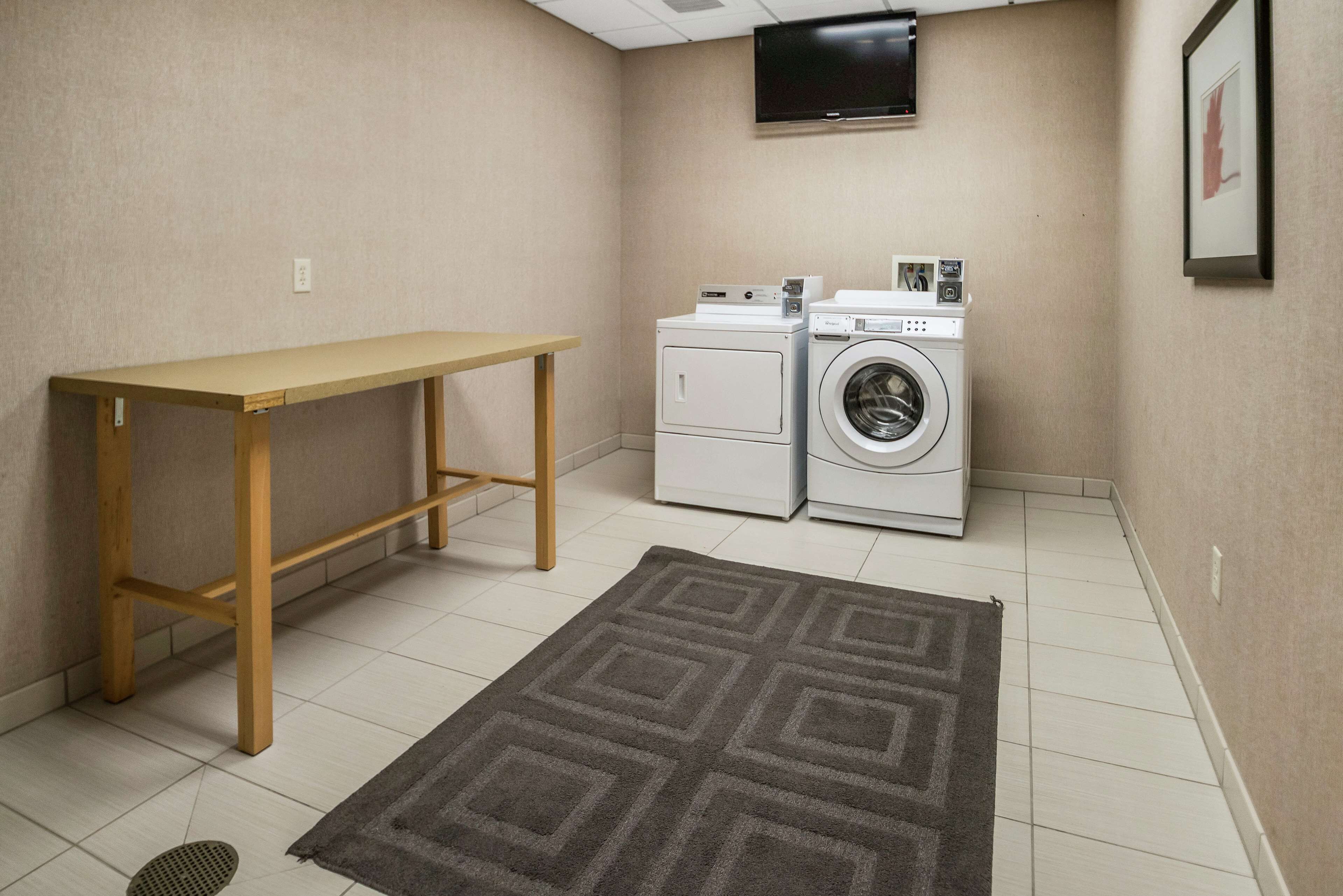 A laundry room with a washing machine, dryer, and a table.