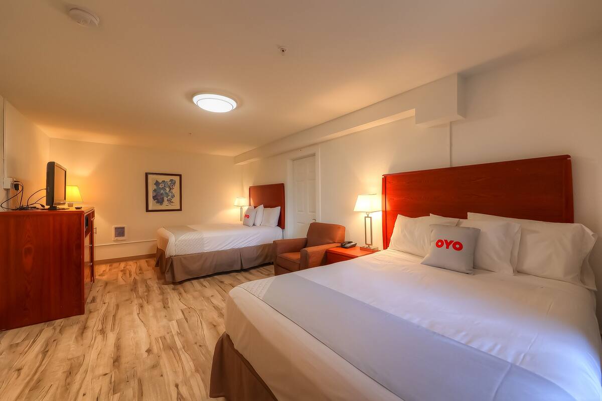 Une chambre d’hôtel avec deux lits, un bureau et une chaise.