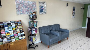 Una habitación con un sofá azul, un mapa en la pared y un expositor de folletos.