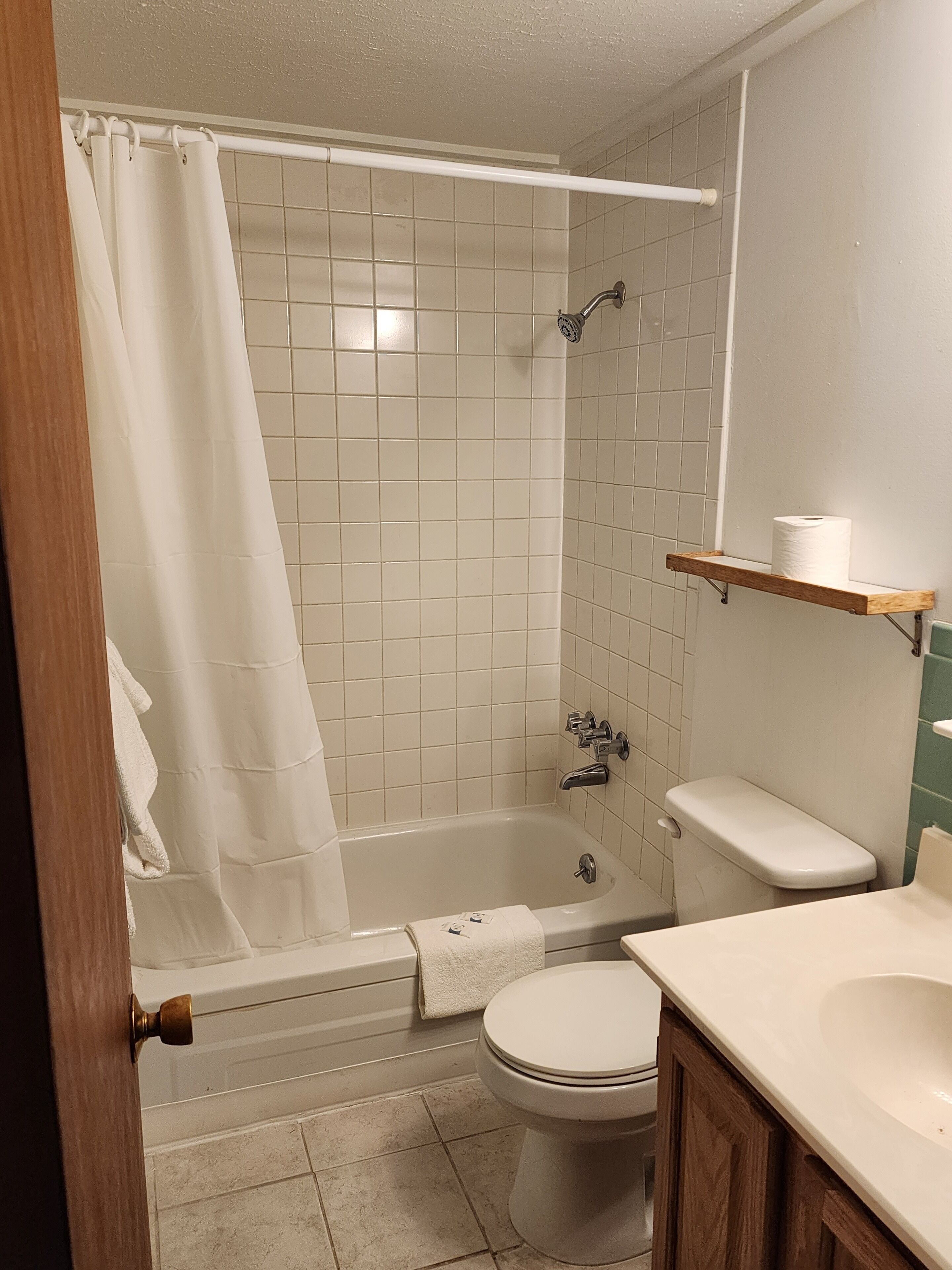A bathroom with a bathtub, toilet, and sink.