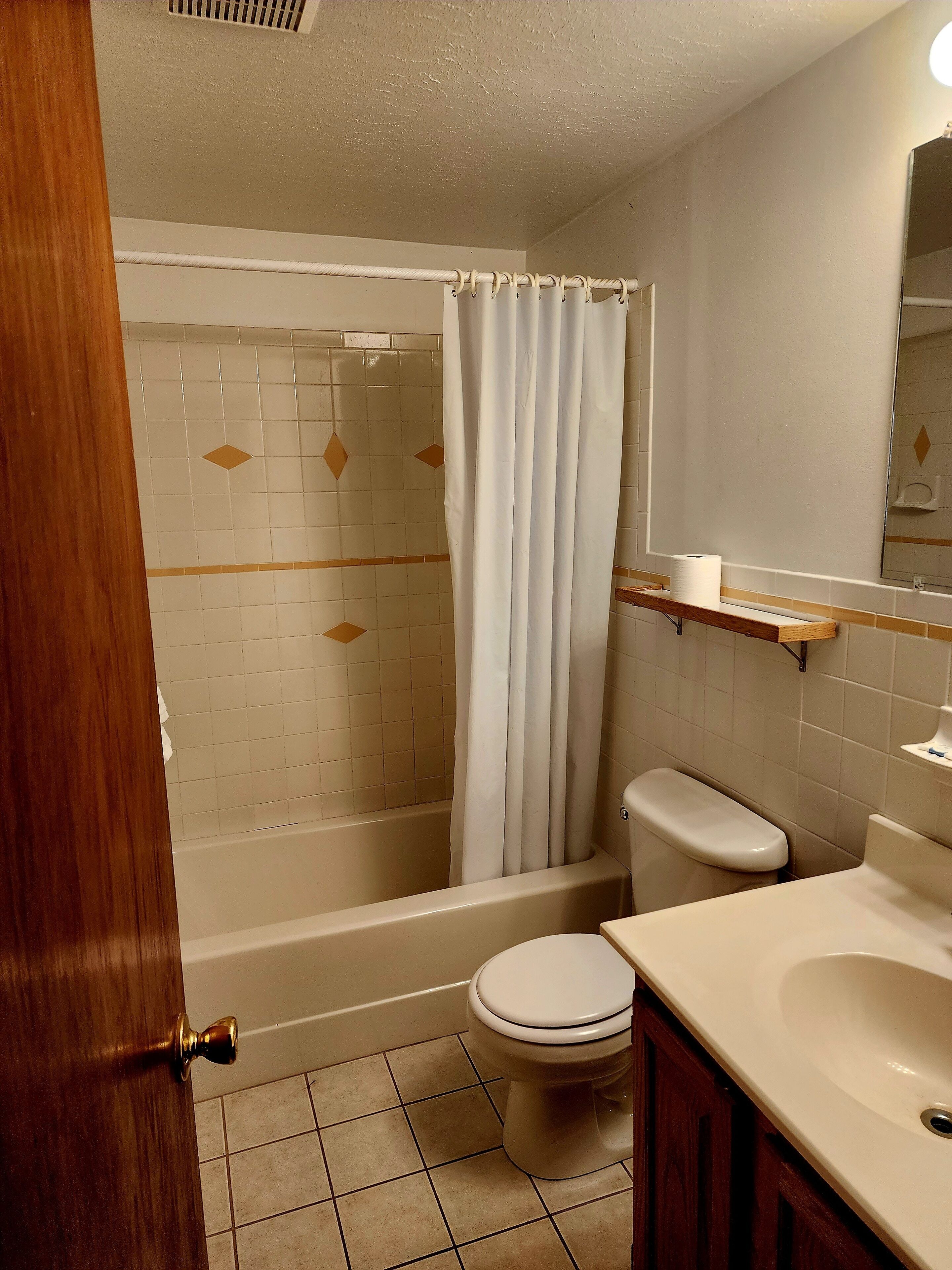 Un baño con bañera, inodoro y lavamanos.
