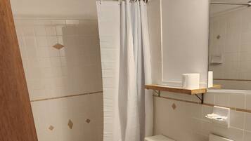 A bathroom with a bathtub, toilet, and sink.