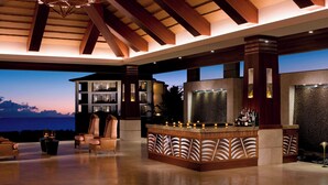 A spacious lounge area with a bar, comfortable seating, and a view of the ocean. - Koloa Landing Resort at Poipu, Autograph Collection (Koloa)