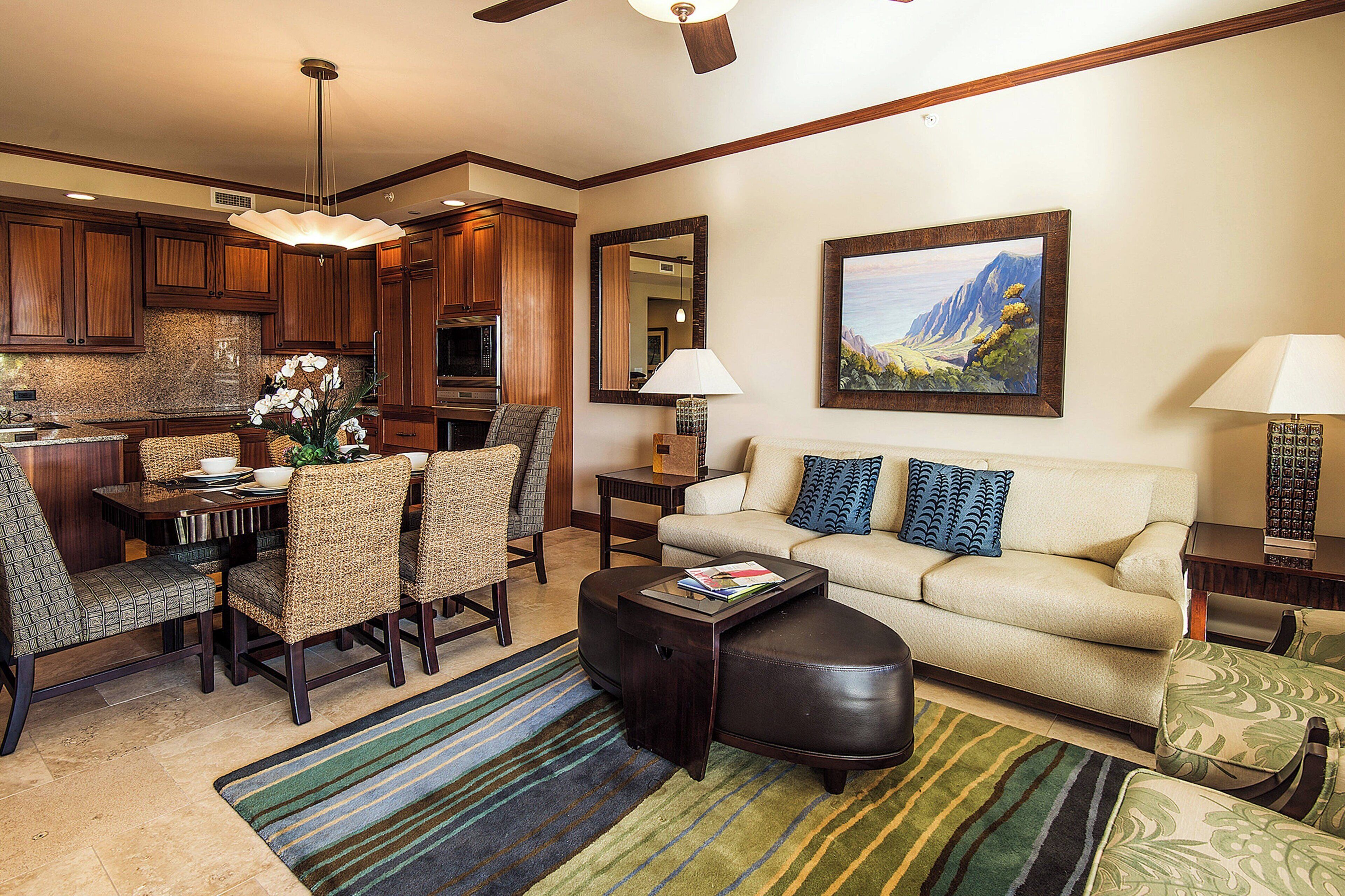 A well-lit living room with a sofa, chairs, a coffee table, and a dining area with a table and chairs.