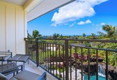 A balcony with a view of a tropical garden and a waterfall.