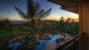 A resort with a large pool area, palm trees, and a view of the ocean at sunset. - Koloa Landing Resort at Poipu, Autograph Collection (Koloa)