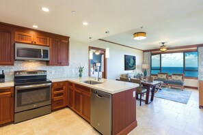 A modern kitchen with built-in appliances, a dining area with a view, and a spacious living room.